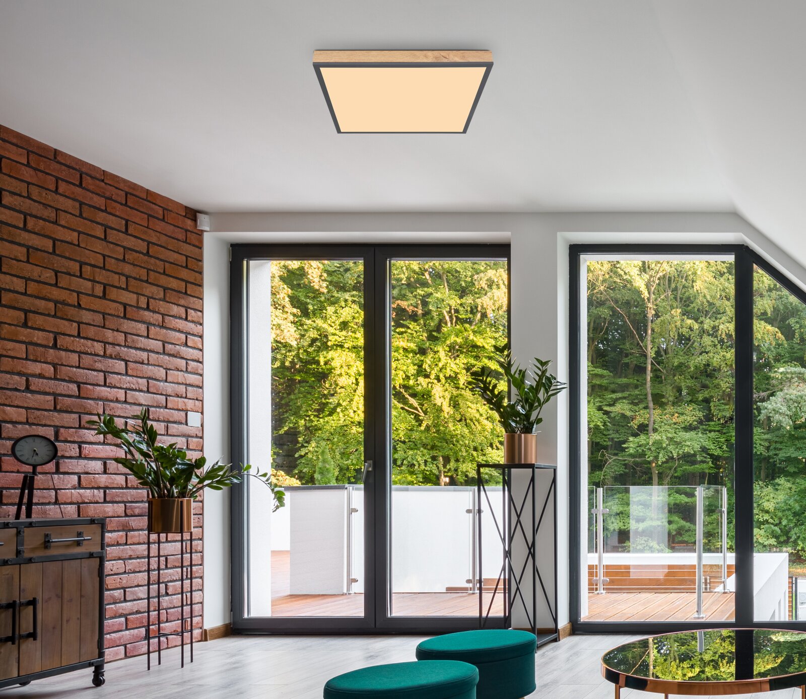 Moderne Deckenleuchte in einem stilvollen Wohnzimmer mit Blick auf große Fenster und grüne Bäume.