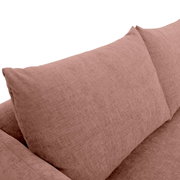 Close-up van een roze zithoek met zachte kussens.