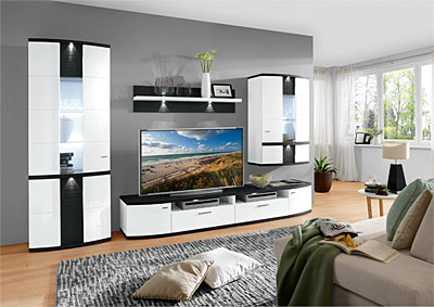 Moderne Wandkombination in einem Wohnzimmer, bestehend aus weißen und schwarzen Schränken mit Glasfronten, einem großen Fernseher in der Mitte und dekorativen Elementen. Perspektive von vorne.
