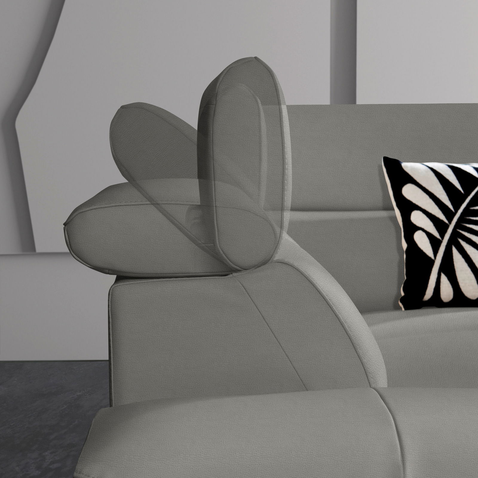 Graue Eckgarnitur mit verstellbarer Kopfstütze und dekorativem Kissen, seitliche Perspektive