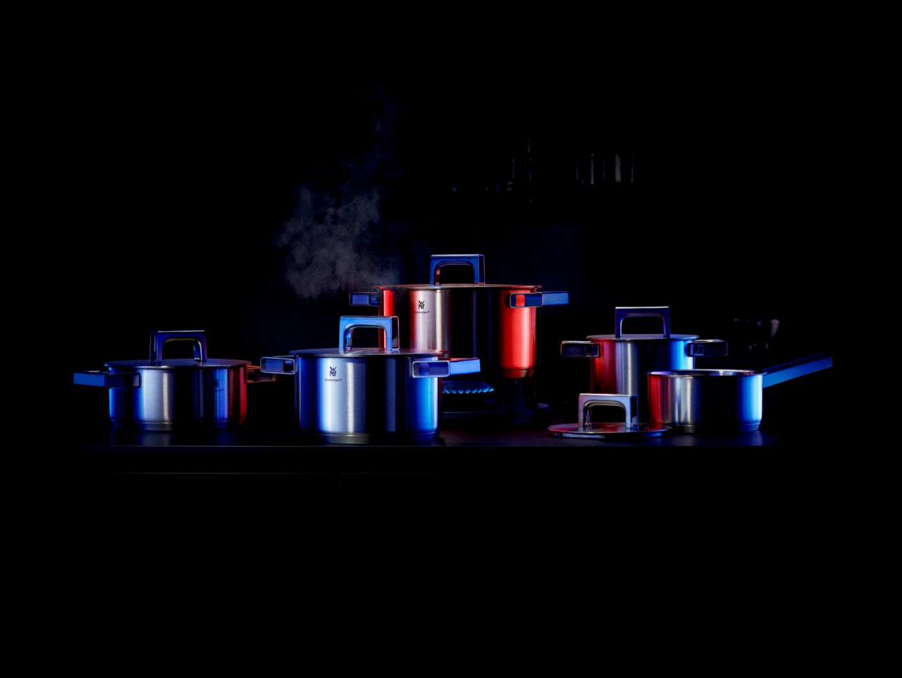 WMF Ultimate Cool Topf-Set 5-teilig in moderner Küche, seitliche Perspektive, mit Dampf aufsteigend aus einem Topf.