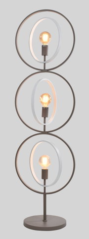 Frontaal aanzicht van een moderne bruine vloerlamp met ronde voet, drie gestapelde metalen ringen en drie warm brandende filamentlampen in witte binnenringen