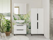 Moderner weißer Midischrank im Badezimmer, frontal fotografiert, neben einem Waschbecken mit Spiegel und Pflanzen.