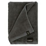 Graues Handtuchset aus Frottierstoff, gefaltet und von oben fotografiert, mit sichtbarem Etikett.