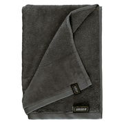 Graues Handtuchset aus Frottierstoff, gefaltet und von oben fotografiert, mit sichtbarem Etikett.