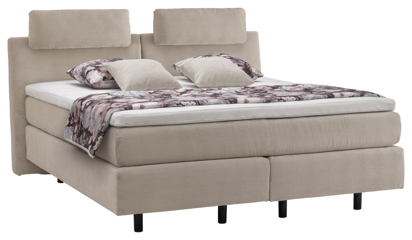 Beiges Boxspringbett mit zwei Kopfstützen, dekoriert mit gemusterten Kissen und einer Decke, seitliche Perspektive