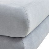 Nahaufnahme eines grauen Funktionssofas mit weicher Polsterung, seitliche Perspektive