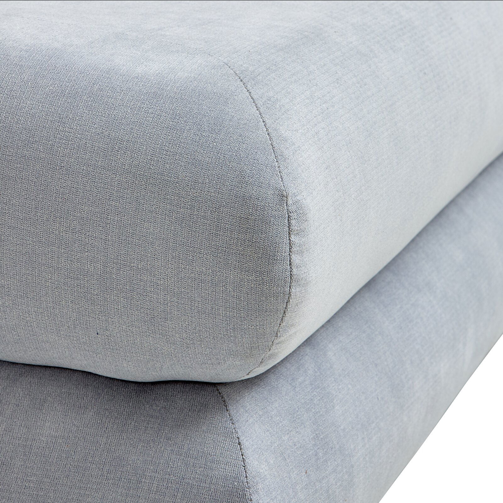 Nahaufnahme eines grauen Funktionssofas mit weicher Polsterung, seitliche Perspektive