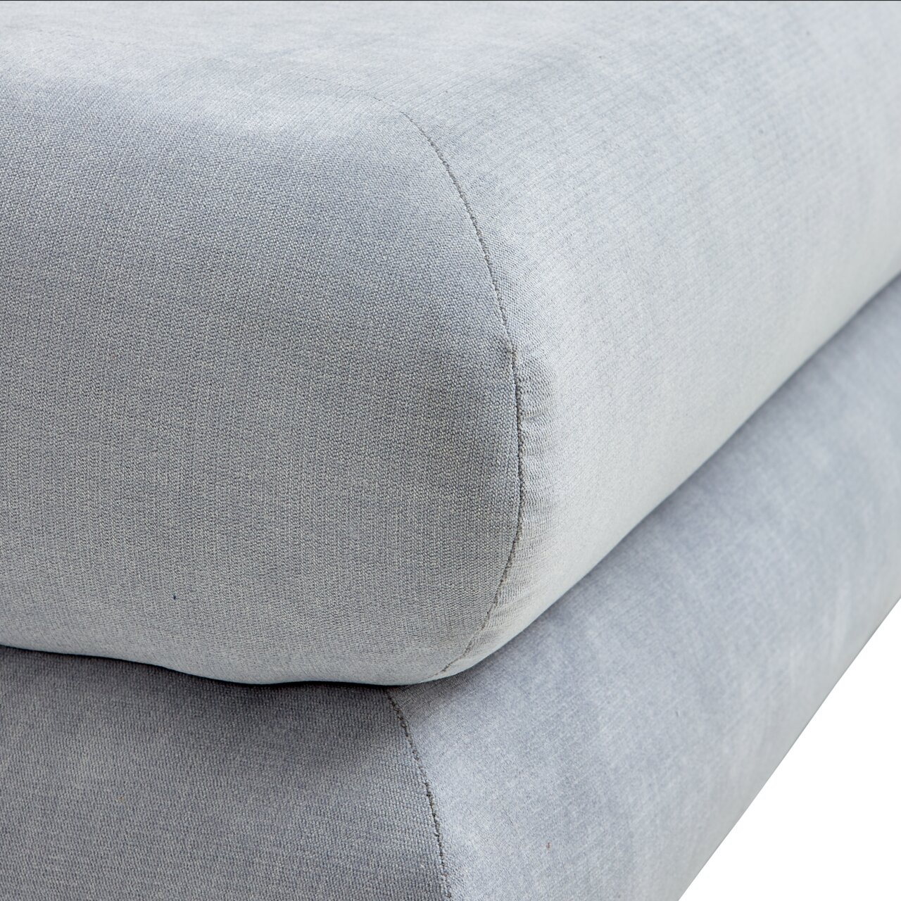 Nahaufnahme eines grauen Funktionssofas mit weicher Polsterung, seitliche Perspektive