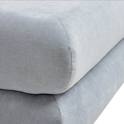 Nahaufnahme eines grauen Funktionssofas mit weicher Polsterung, seitliche Perspektive