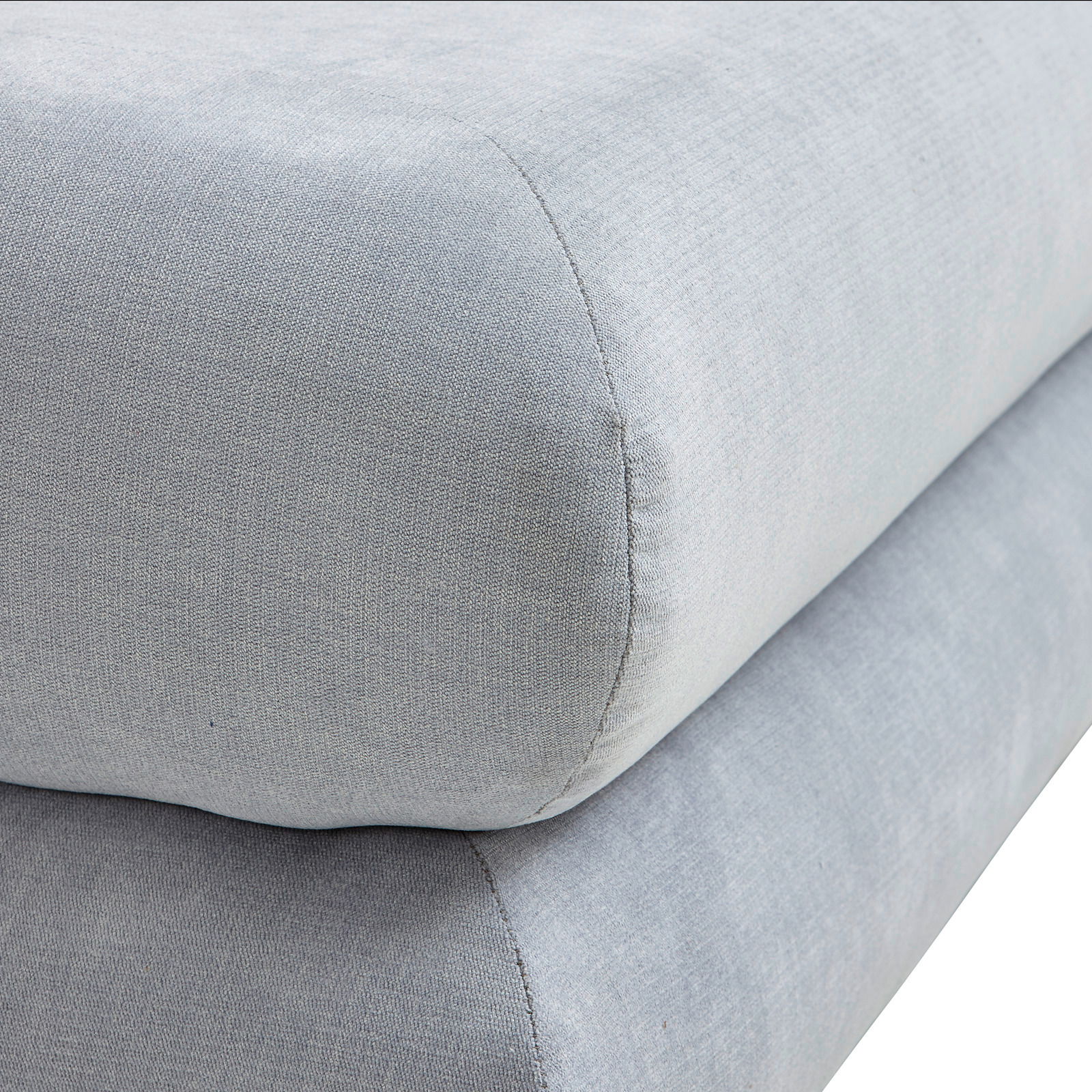 Nahaufnahme eines grauen Funktionssofas mit weicher Polsterung, seitliche Perspektive