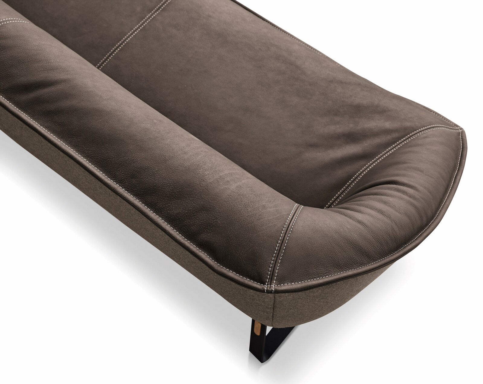 Nahaufnahme einer braunen Ledereckbank Koinor SOFTY mit sichtbaren Nähten und schwarzem Bein, Perspektive von oben.