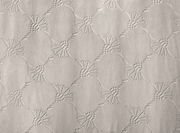 Nahaufnahme eines Dekoschals mit einem strukturierten, geometrischen Muster in neutralen Tönen.