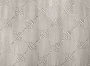 Nahaufnahme eines Dekoschals mit einem strukturierten, geometrischen Muster in neutralen Tönen.