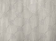 Nahaufnahme eines Dekoschals mit einem strukturierten, geometrischen Muster in neutralen Tönen.