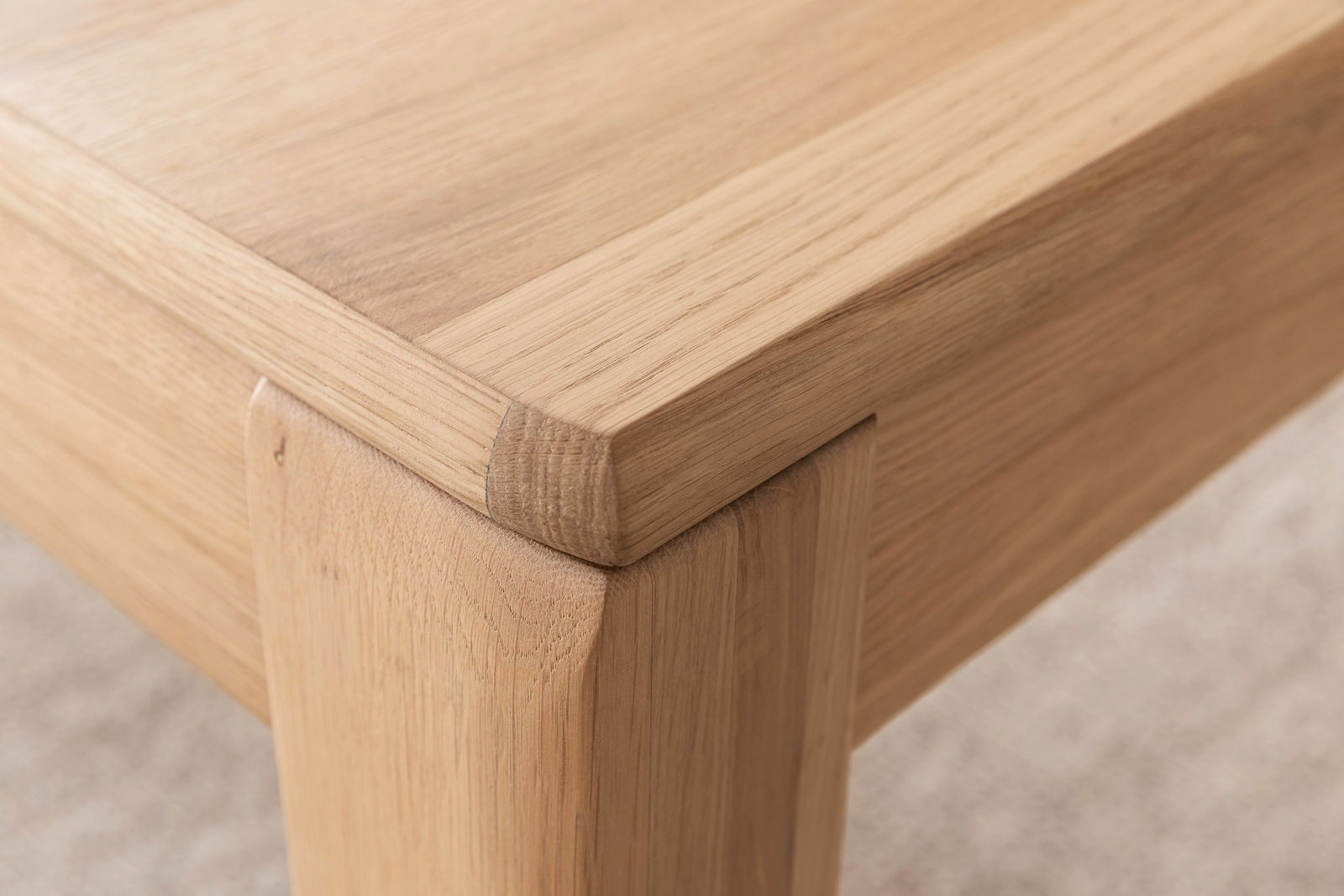 Nahaufnahme eines Couchtisches aus Holz mit sichtbarer Maserung, Perspektive von der Ecke des Tisches.