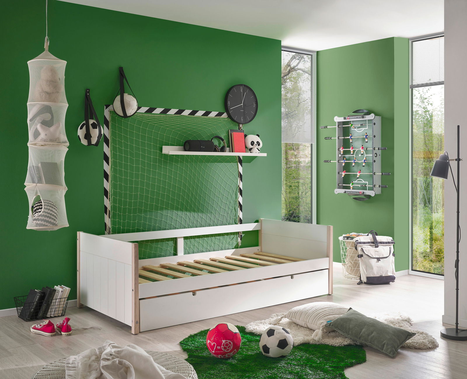 Jugendbett in einem sportlich dekorierten Zimmer mit Fußballthema, seitliche Perspektive