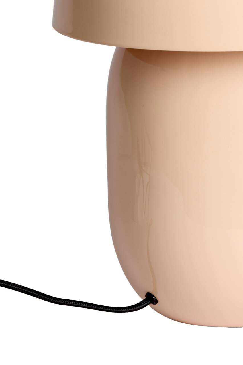 Close-up van een beige tafellamp met een glanzend oppervlak en een zwarte kabel.
