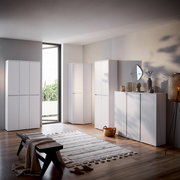 Moderner weißer Schuhschrank in einem stilvoll eingerichteten Raum, seitliche Perspektive