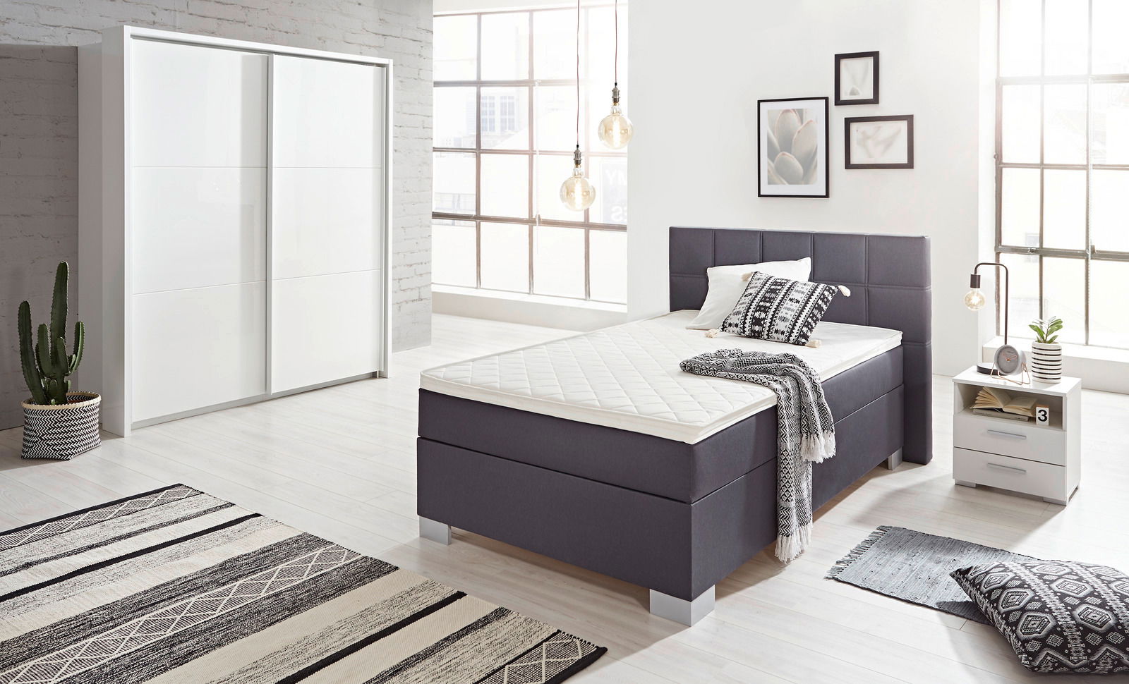 Moderner, weißer Schwebetürenschrank mit zwei Türen in einem stilvoll eingerichteten Schlafzimmer, seitliche Perspektive.