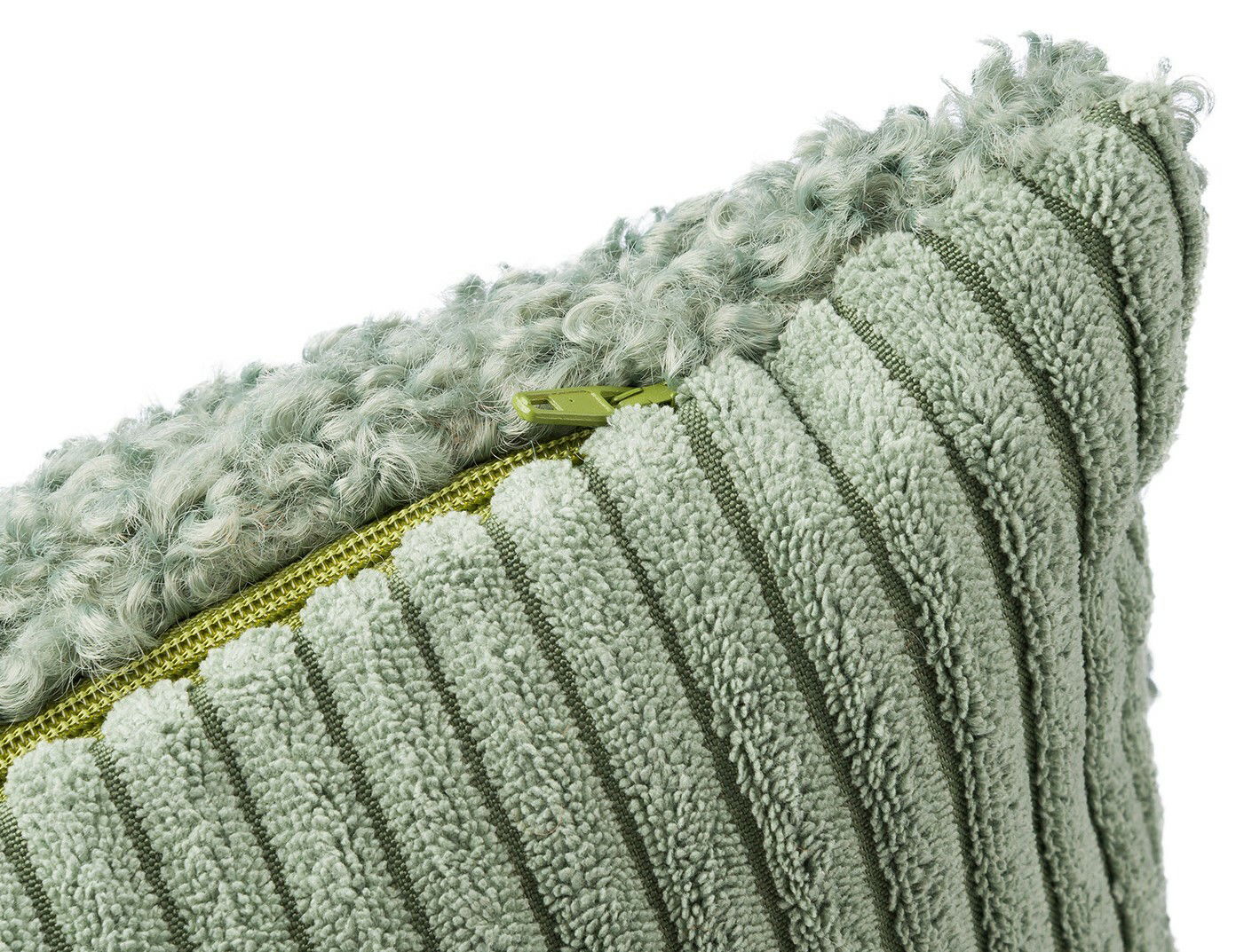 Nahaufnahme einer grünen Kissenhülle mit strukturiertem Stoff und Reißverschluss.