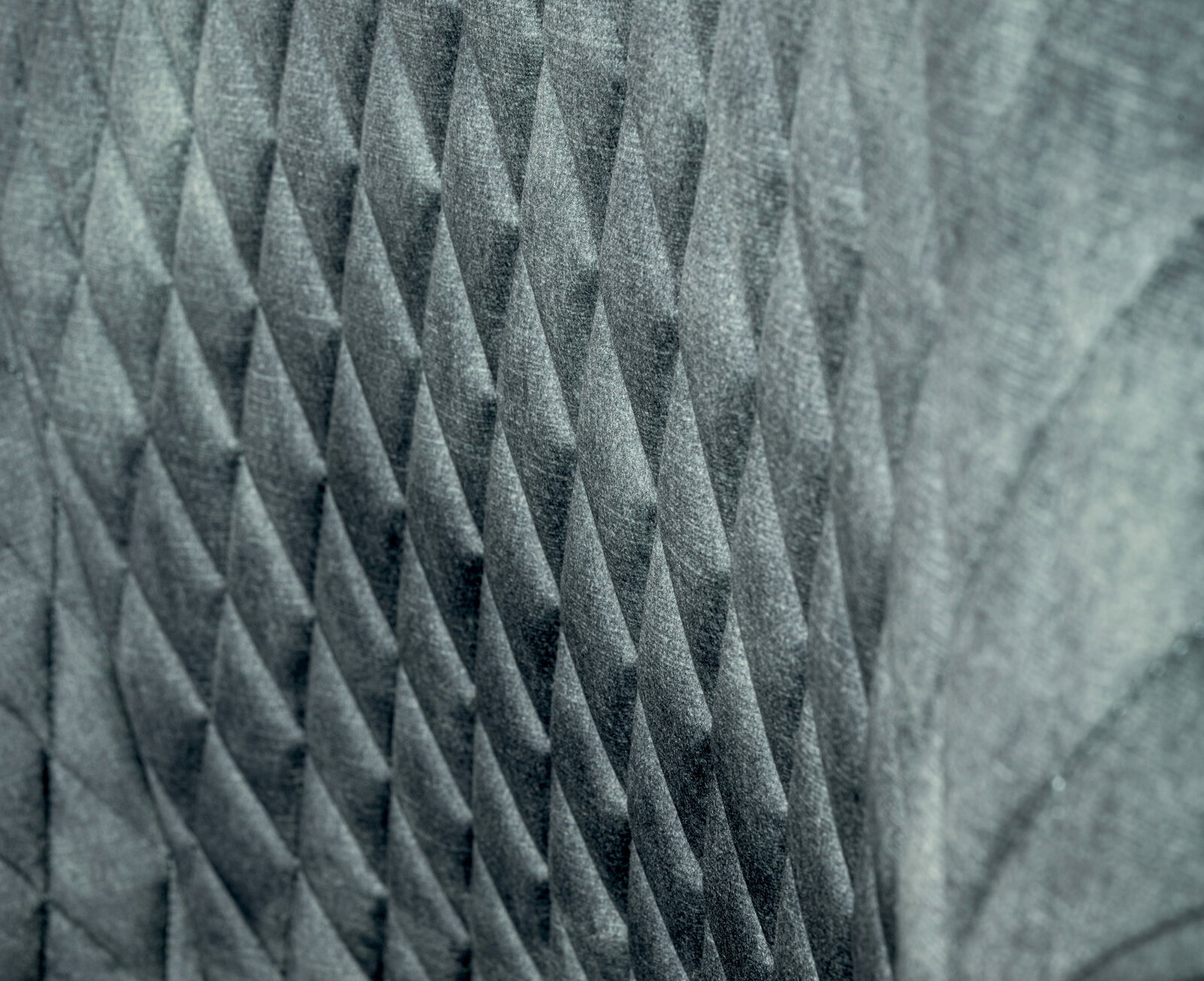 Nahaufnahme der strukturierten Rückenlehne eines Drehstuhls mit geometrischem Muster.