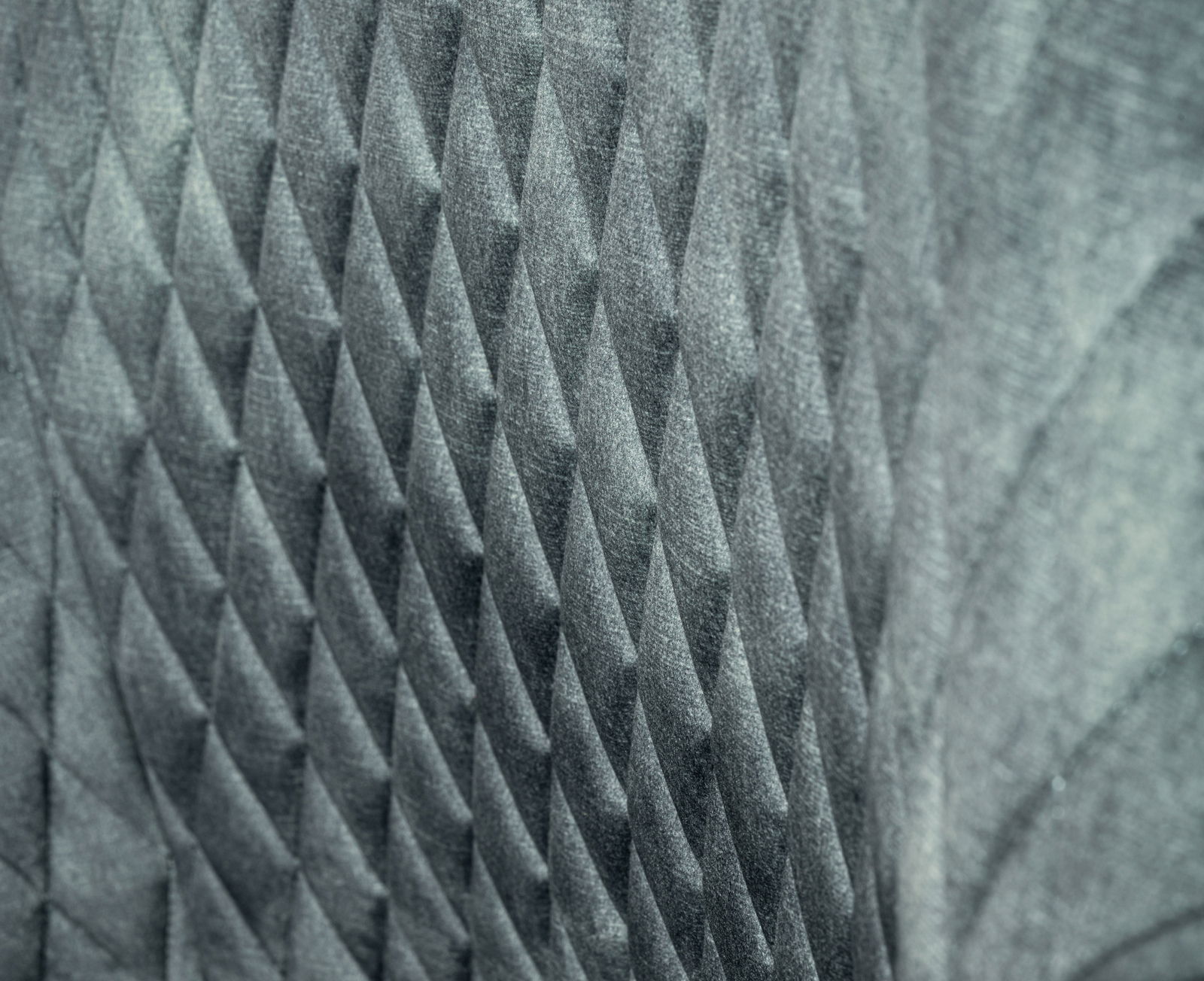 Nahaufnahme der strukturierten Rückenlehne eines Drehstuhls mit geometrischem Muster.