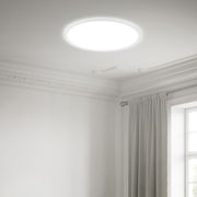 Runde LED-Deckenleuchte in einem eleganten Raum, von unten betrachtet.