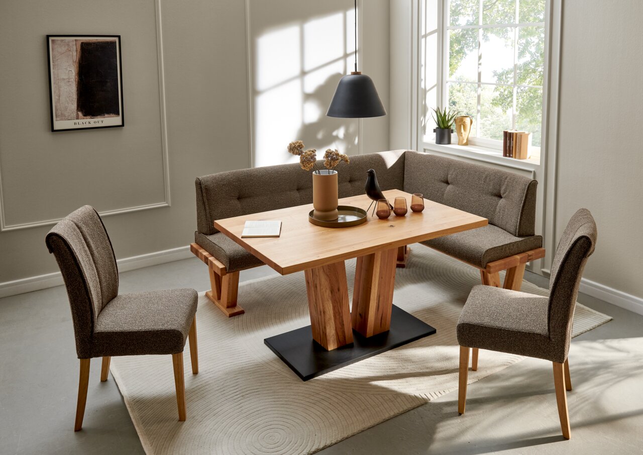 Valdera Eckbank ALEGRA II Eckbankgruppe in einem modernen Esszimmer mit Holztisch und gepolsterten Stühlen, seitliche Perspektive.