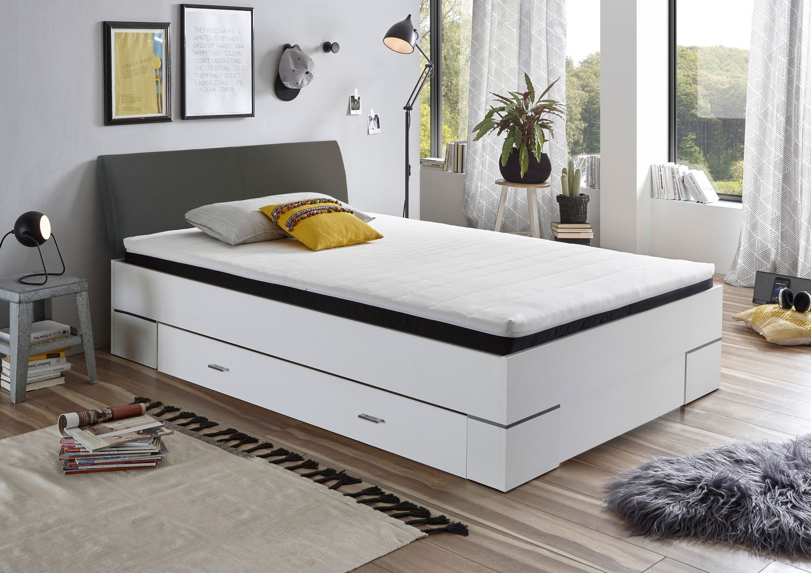 Modernes Bettgestell mit Stauraum, seitliche Perspektive, in einem stilvoll eingerichteten Schlafzimmer mit großen Fenstern.