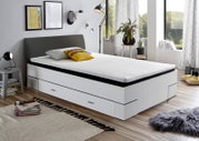 Modernes Bettgestell mit Stauraum, seitliche Perspektive, in einem stilvoll eingerichteten Schlafzimmer mit großen Fenstern.