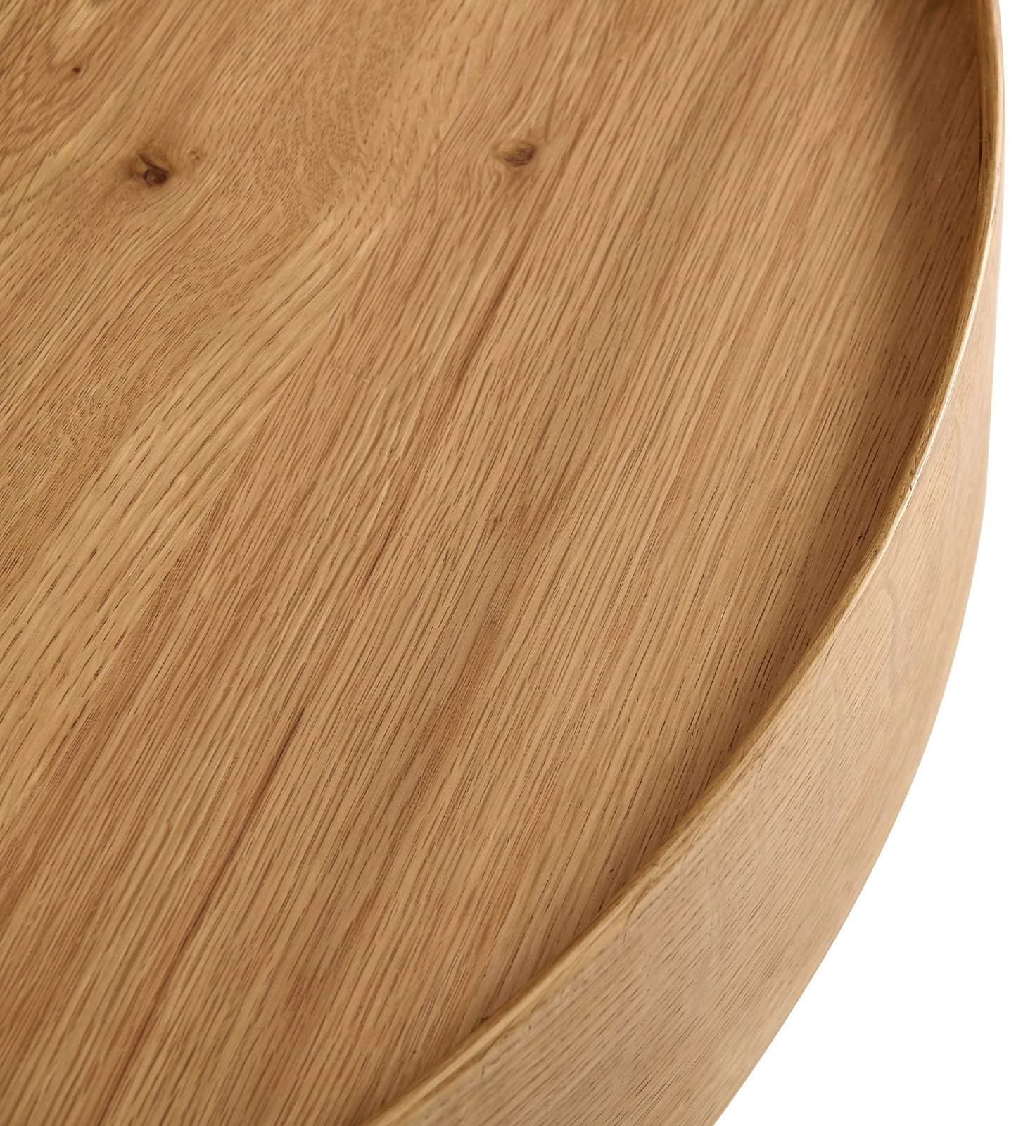 Nahaufnahme eines runden Couchtisches aus Holz mit sichtbarer Maserung, von oben betrachtet.
