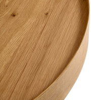 Nahaufnahme eines runden Couchtisches aus Holz mit sichtbarer Maserung, von oben betrachtet.