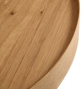 Nahaufnahme eines runden Couchtisches aus Holz mit sichtbarer Maserung, von oben betrachtet.