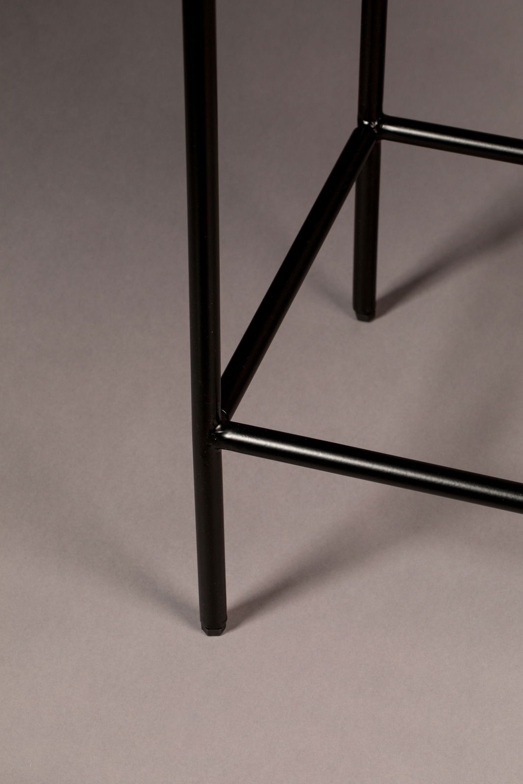 Nahaufnahme eines schwarzen Metallbeins eines Highboards, von der Seite betrachtet.