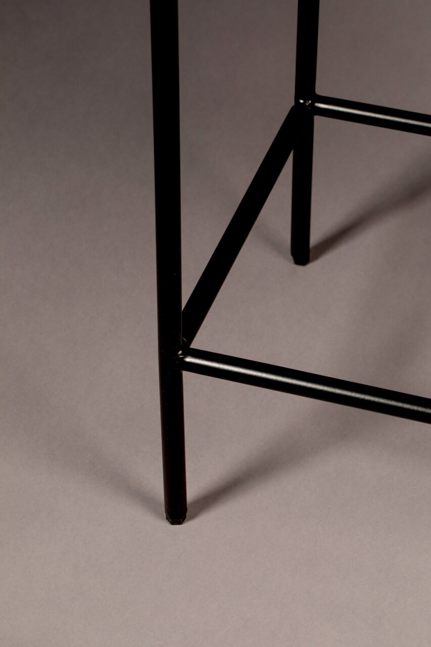 Close-up van een zwart metalen poot van een hoog dressoir, gezien vanaf de zijkant.