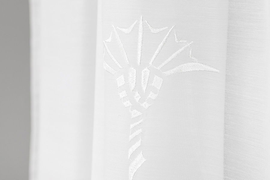 Nahaufnahme eines weißen Vorhangs mit floralem Muster, seitliche Perspektive