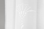 Nahaufnahme eines weißen Vorhangs mit floralem Muster, seitliche Perspektive