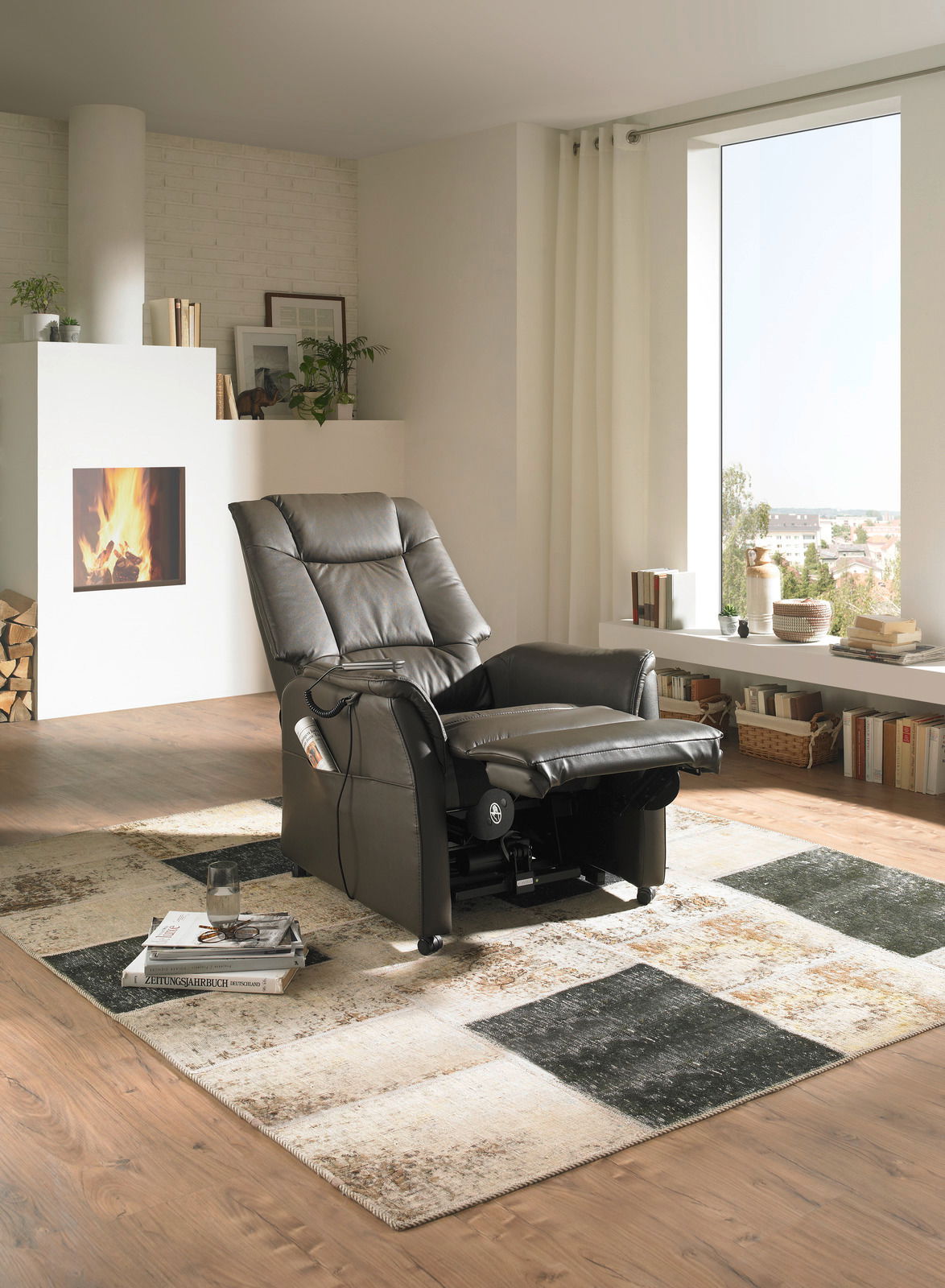 Schwarzer Fernsehsessel in einem modernen Wohnzimmer mit Kamin, aus seitlicher Perspektive.