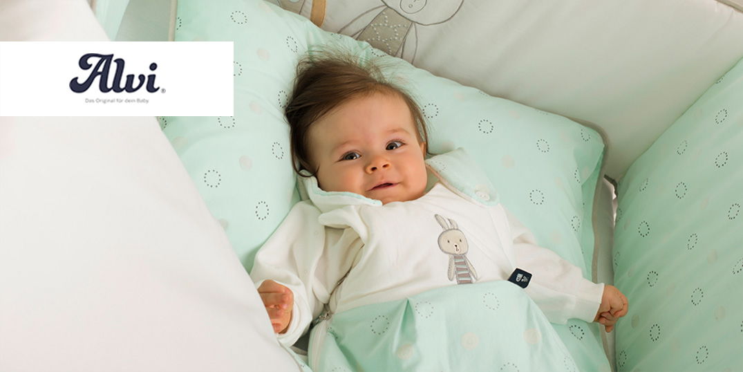 Ein friedliches Baby liegt in einem Bettchen, umgeben von weicher, mintgrüner Bettwäsche mit bezaubernden Mustern und einem verspielten Häschenmotiv.