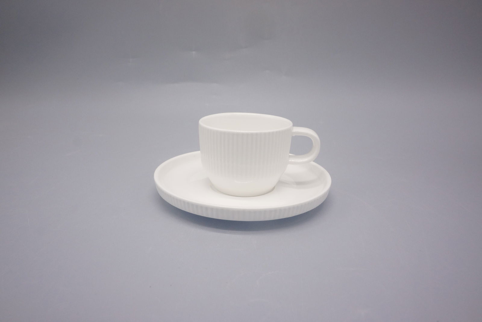 Weiße Espressotasse mit Untertasse aus Porzellan, seitliche Perspektive