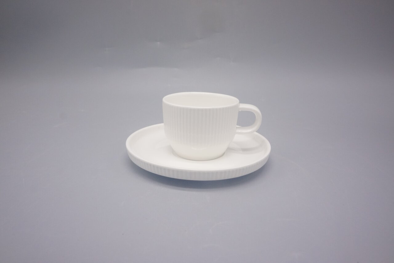 Weiße Espressotasse mit Untertasse aus Porzellan, seitliche Perspektive