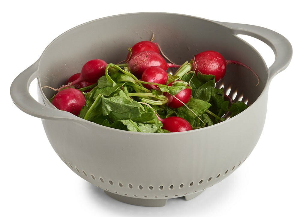 Grauer Kunststoff-Sieb mit Griffen, gefüllt mit frischen Radieschen, aus der Vogelperspektive.