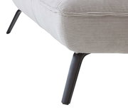 Nahaufnahme eines Longchairs mit hellgrauem, geripptem Stoffbezug und schwarzen Metallbeinen, seitliche Perspektive.