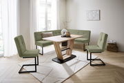 Moderne Esszimmer-Eckbankgruppe mit grünem Stoffbezug und Holztisch in einem hellen Raum, seitliche Perspektive.