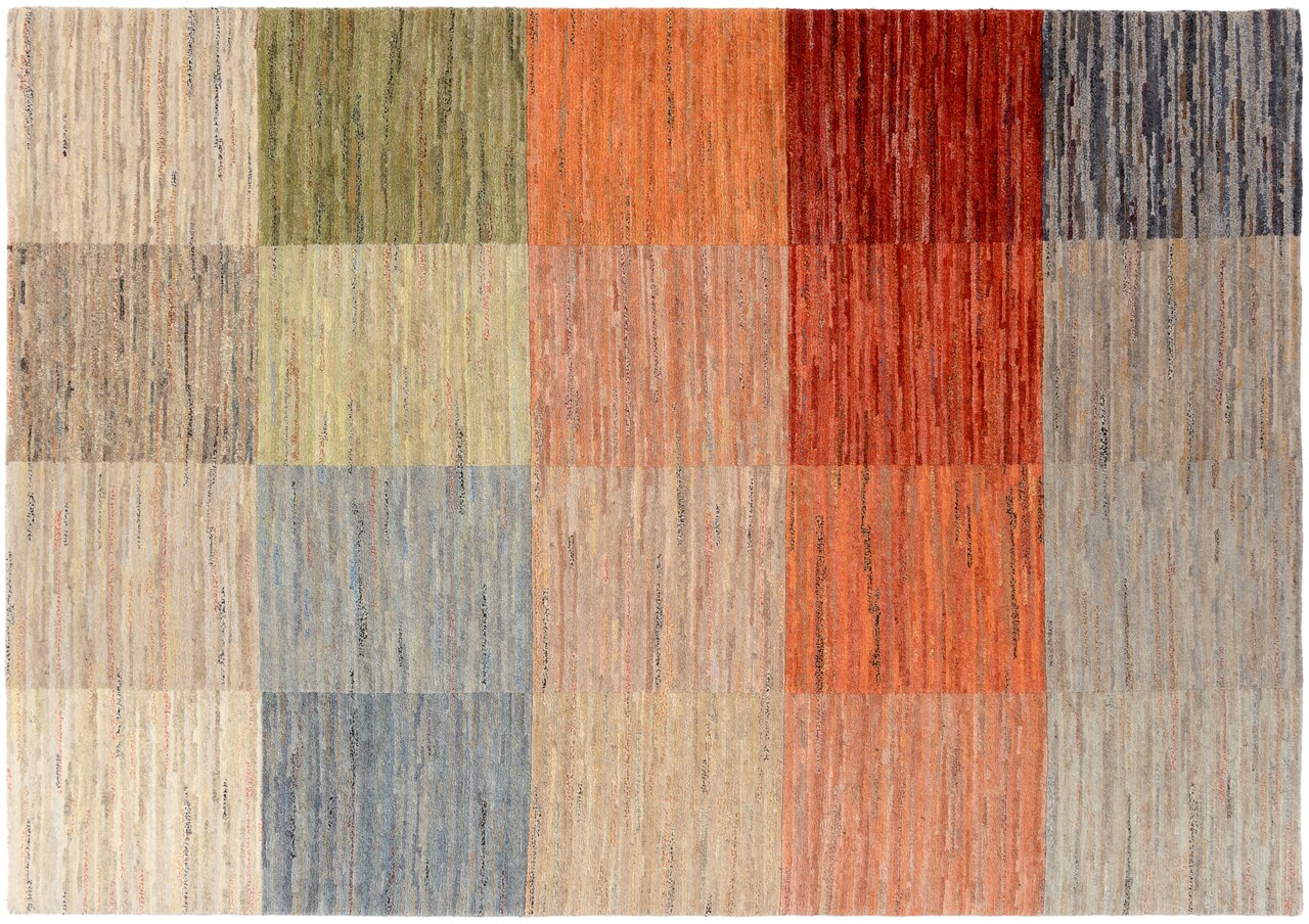 Vogelperspektive auf einen mehrfarbigen Wollteppich mit einem Muster aus rechteckigen Farbblöcken in verschiedenen Tönen von Grün, Rot, Blau und Beige.