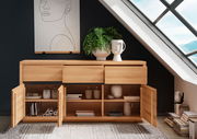 Holz-Sideboard mit offenen Schubladen und Türen, dekoriert mit Pflanzen und Keramik, in einem modernen Raum unter einem Dachfenster, Frontalansicht.