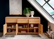 Holz-Sideboard mit offenen Schubladen und Türen, dekoriert mit Pflanzen und Keramik, in einem modernen Raum unter einem Dachfenster, Frontalansicht.
