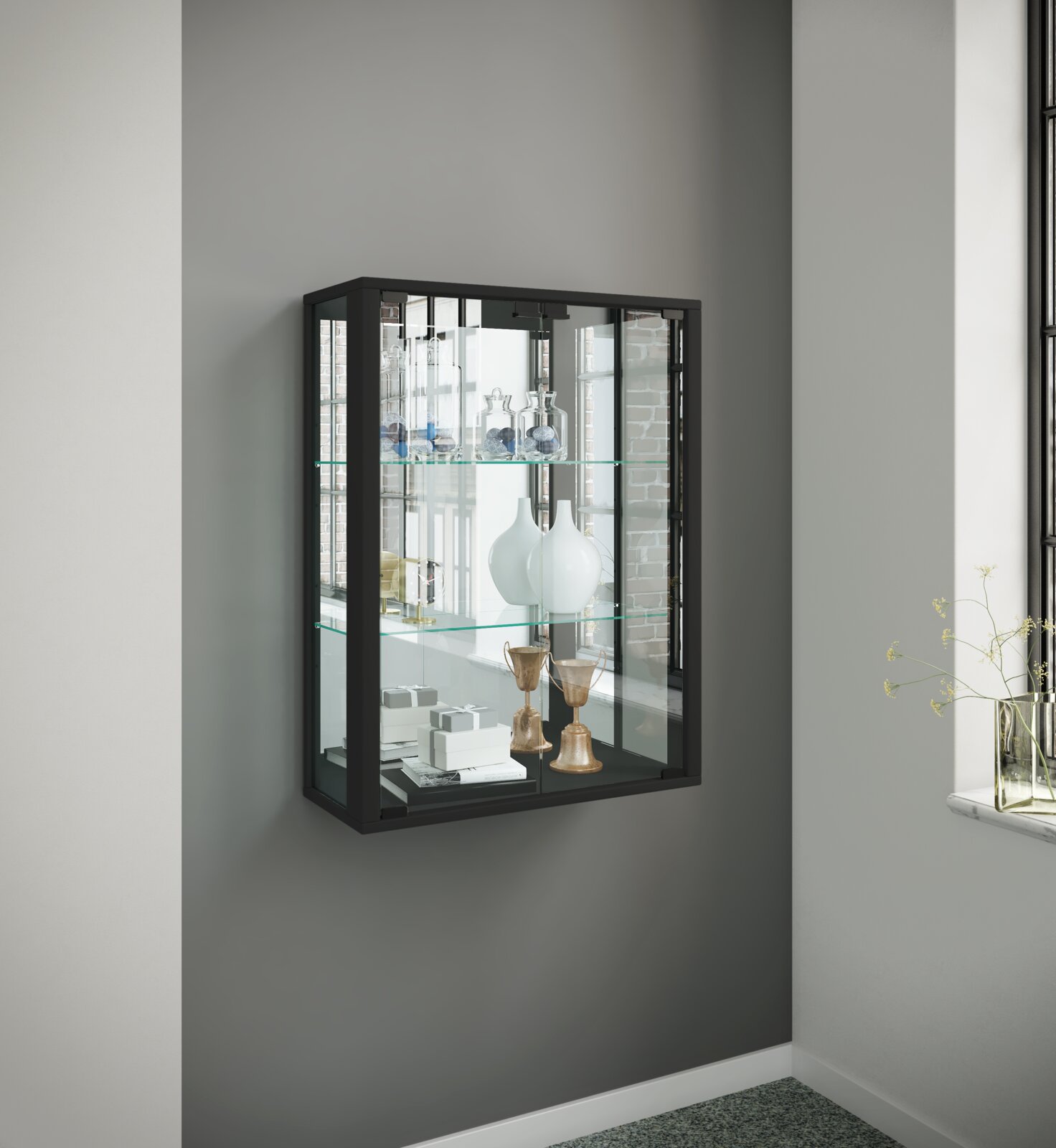 Schwarze, wandmontierte Glasvitrine mit Metallrahmen und Glaseinlegeböden, dekoriert mit Vasen und Accessoires; Perspektive: leicht schräg von vorn links.