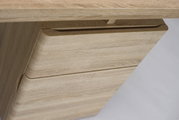Nahaufnahme eines Schreibtisches aus hellem Holz mit Schubladen, seitliche Perspektive.